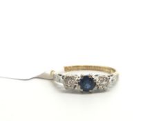 Sapphire and diamond three stone ring, central round cut sapphire mounted with an illusion set