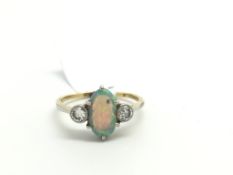 Opal and diamond ring, oval cabochon cut opal set with a transitional cut diamond rub over set to