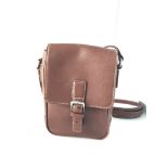 A Coach brown leather shoulder bag with white contrast stitching, magnetic closure and brown