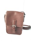 A Coach brown leather shoulder bag with white contrast stitching, magnetic closure and brown