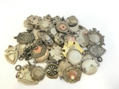 A quantity of mostly antique fobs including silver and gold, enamel and gilt examples