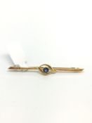 Blue stone set bar brooch, circular blue stone collet set, approximately 55mm long, stamped 15ct