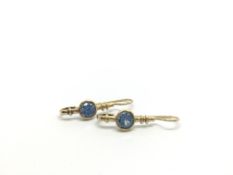Blue stone set earrings, rub over set in yellow metal stamped and tested as 9ct