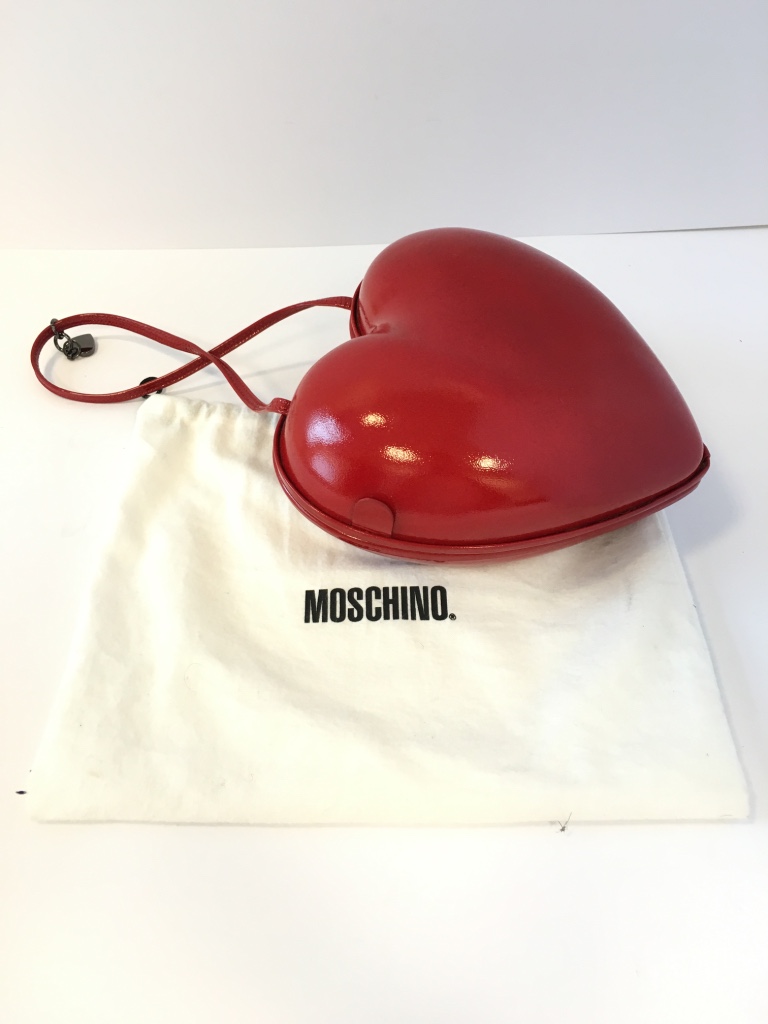 A Moschino â€œLoveâ€ heart shaped evening bag, the moulded bag covered in red shiny material, the