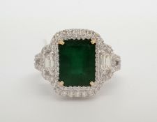 Emerald and diamond cluster ring, central step cut emerald weighing an estimated 2.70cts, surrounded