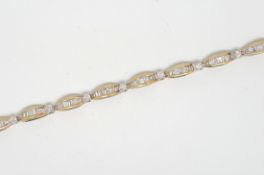 Diamond line bracelet, sixteen links of graduated baguette cut diamonds, each separated by a claw