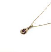 Ruby pendant, pear cut ruby rub over set, suspended for a yellow gold chain, all stamped and