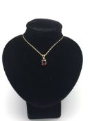 Garnet and diamond necklace, oval cut garnet set with a single small diamond, split bail, fine