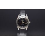 A GENTLEMEN'S W10 MILITARY HMT STAINLESS STEEL WRIST WATCH, black dial with luminous markers and