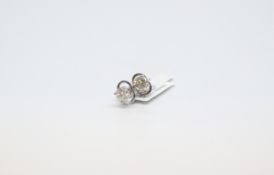 A pair of round cut diamond studs. Total carat weight 0.98cts. 18ct white gold with butterfly