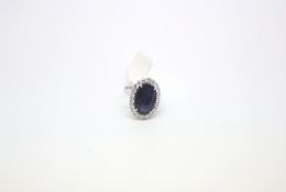 Sapphire and diamond cluster ring, large oval cut sapphire 15.8x10.7mm claw set with a cluster of