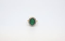 Emerald and diamond cluster ring, oval cut Emerald 12.5x9.8mm weighing an estimated 4.00ct, set with