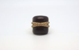 A large diamond and resin ring in yellow metal. wood effect resin panel is set with two bands of