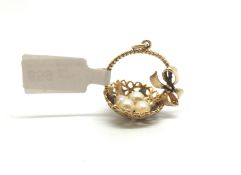 A 9ct Gold Charm depicting a basket with pearl details and a gem set bow. 4.7g