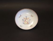 An 18th Century Chinese armorial circular saucer depicting a central crest with floral surround.