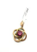 A gold pendant set with a red gemstone. Tested as 9ct. 3.1g