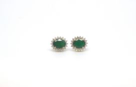 Emerald and diamond cluster earrings, oval cut emeralds estimated weight 3.25ct each, set with a