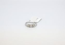 A multi stone 18ct gold diamond ring. Three round cuts with baguette diamond shoulder accents. 1.