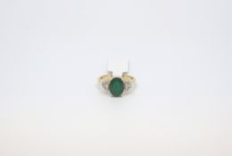 Emerald and diamond ring, central oval cut emerald 9.9x7.7mm, set with a brilliant cut diamond to