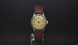 A Gentlemen's MILITARY TIMOR WATCH MARKED ATP. The dial is yellow with a outer track and arabic