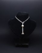 Cartier So Pretty diamond and pearl necklace, 9mm black pearl suspended from 7.5mm white pearl,