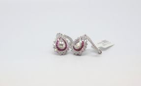 A pair of Diamond and Ruby Earrings. The rose cut diamonds are surrounded by a ruby halo and further