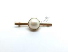 A gold brooch set with a large Mabe pearl. Chinese marks and hallmark for 22k gold. 8.6g