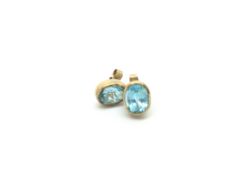 Pair of oval topaz studs, rub over set in 9ct gold, 11x8mm