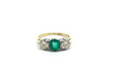 Emerald and Diamond three stone ring. The central emerald flanked by two brilliant cut diamonds.