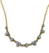 Unusual opal necklace, collet set dark opals set alternately as single and threes across a yellow