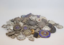 A large selection of silver alberts chains including sheilds and coins, marked and tested silver,