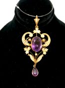 Art Nouveau pendant/brooch. The pendant set with a large amethyst surrounded by seed pearls and