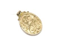 An engraved locket, 3cm x 2.1 (excluding bail). Yellow metal tests as 9ct gold. Approximately 3.