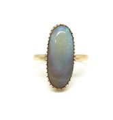 Opal ring, oval cabochon cut opal approximately 2.5x0.8cm, in a closed back setting, in yellow metal