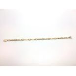 A french 18ct gold diamond set bracelet. Each link interspersed with a bezel set diamond. French