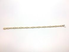 A french 18ct gold diamond set bracelet. Each link interspersed with a bezel set diamond. French