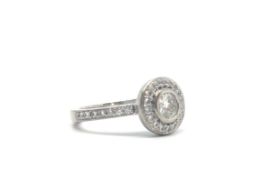 18ct Diamond Halo Ring. The central brilliant cut diamond surrounded by a halo of diamonds with