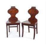 A pair of Regency mahogany carved hall chairs.
