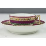 A Meissen cup and saucer with pink ground, painted with flowers and fruit, gilded highlights and
