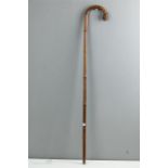 A bamboo sword stick with root ball crook handle.