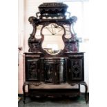 An impressive carved Edwardian Art Nouveau sideboard, with canopied top above the shaped mirrored