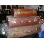 Three leather suitcases of graduated size, early 20th century.