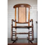 A 19th century mahogany cane back rocking chair.