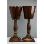 A pair of mahogany jardienere stands with scalloped top and reeded columns raised on stepped bases.