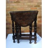 An oval drop leaf table with lunette carving, baluster turned legs.