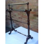 A mahogany towel rail with shaped sides.