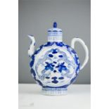 A blue and white Chinese moon flask tea pot with finialled cover and depicting dragons.