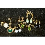 An assorted group of 9ct gold earrings including an opal flowerhead earring. (13)