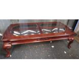 A mahogany coffee table with four smokey bevelled