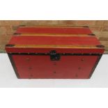 A 19th century trunk, painted in red with oak straps and iron fittings.